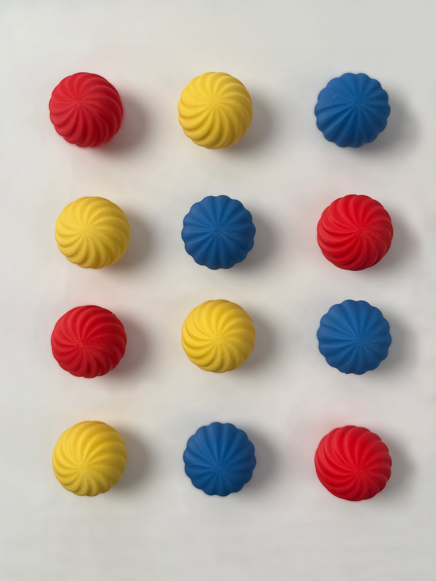 colorful Bauhaus blue , red and yellow colored spherical shaped Christmas ornament on a white background
