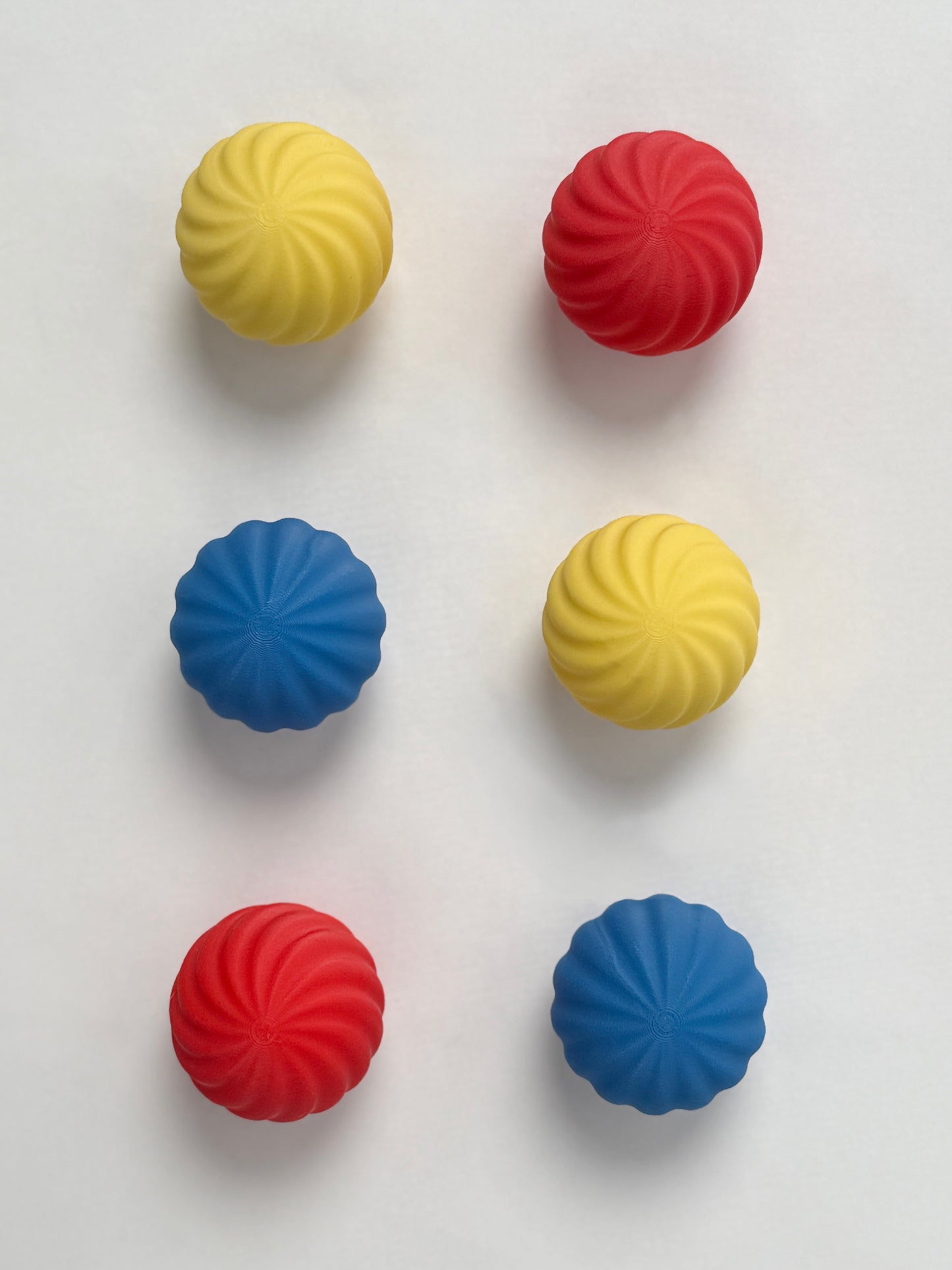 colorful Bauhaus blue , red and yellow colored spherical shaped Christmas ornament on a white background