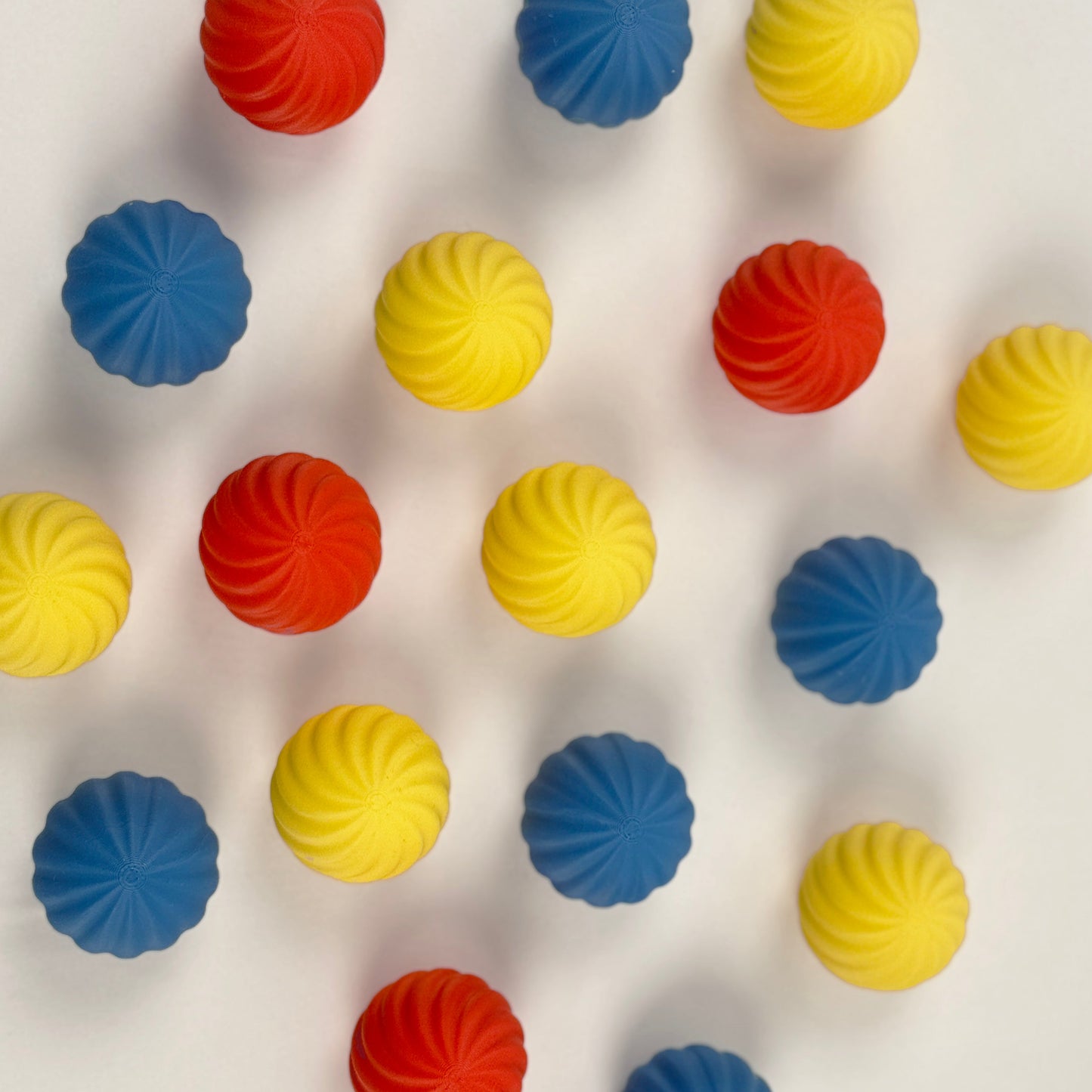 colorful Bauhaus blue , red and yellow colored spherical shaped Christmas ornament on a white background