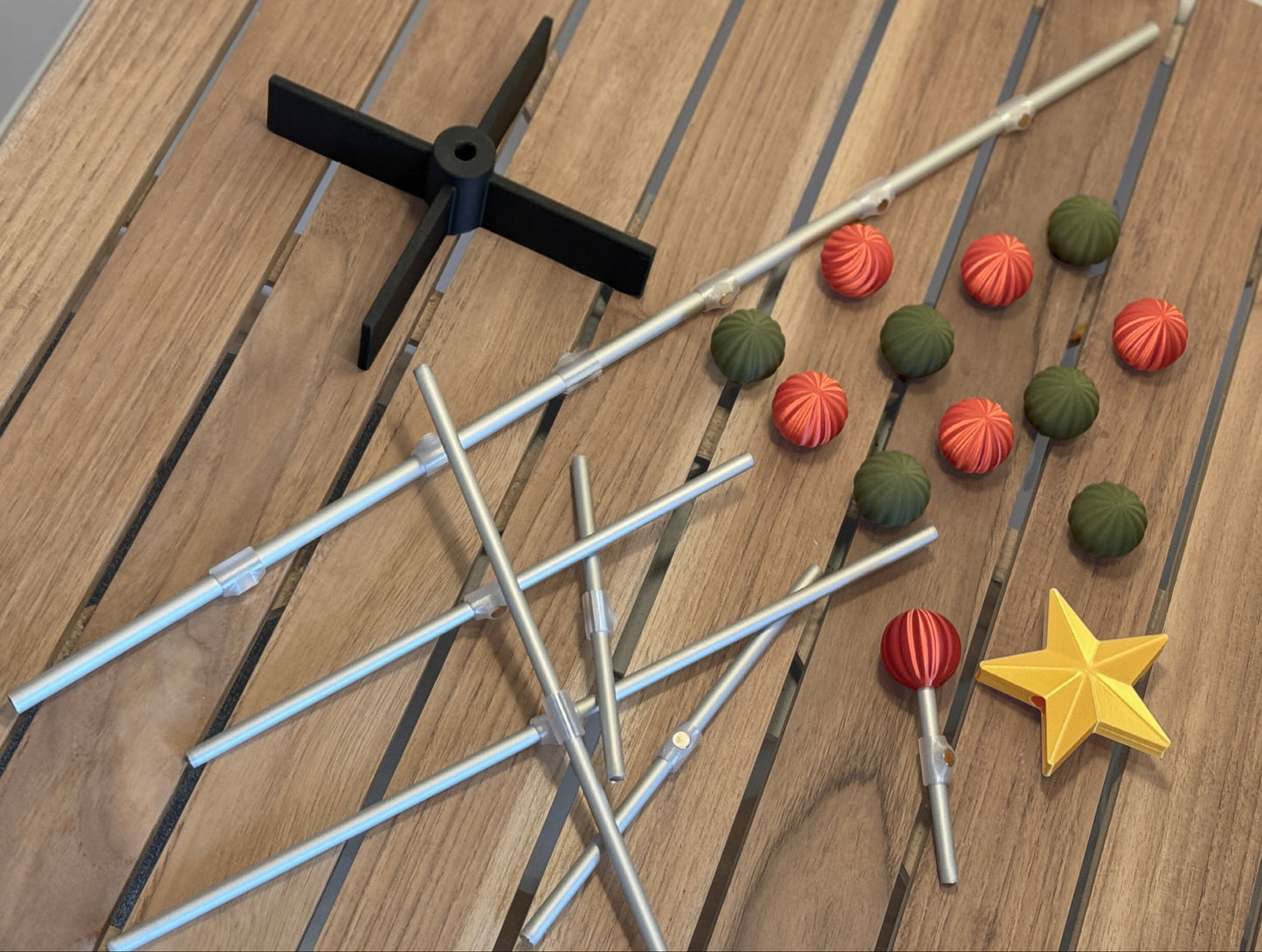 Modern modular for Christmas tree items including sticks, colorful ornament, and a star on a wooden surface