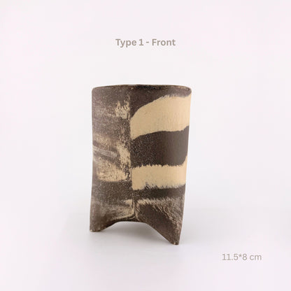A handmade ceramic cup with a textured, organic shape and abstract black and beige stripes, shown on a white background with text overlays indicating 'Type 1 - Front' and dimensions '11.5*8 cm'.