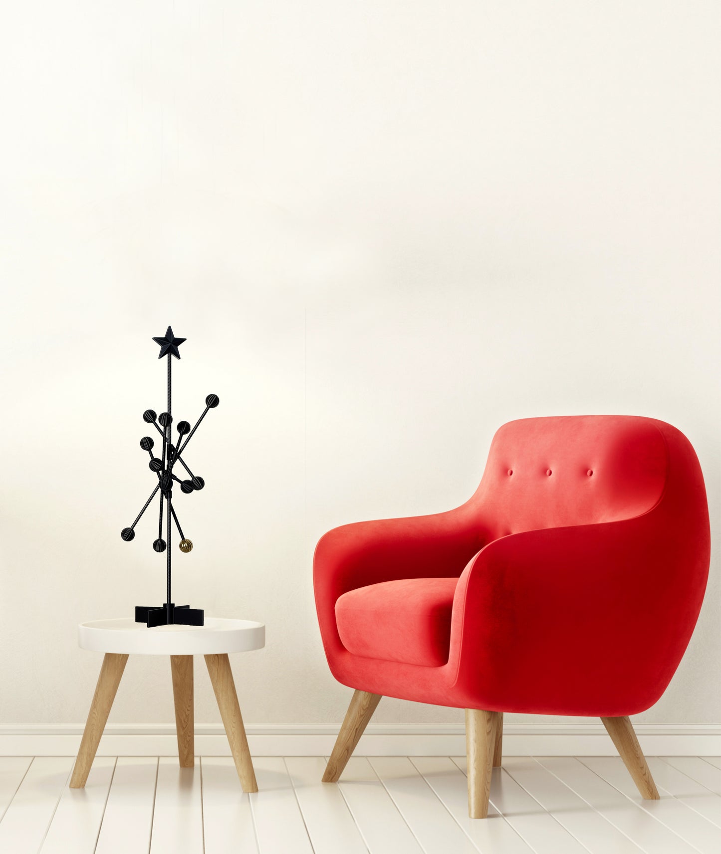 Red armchair next to a small round table with a black decorative sculpture on a white background