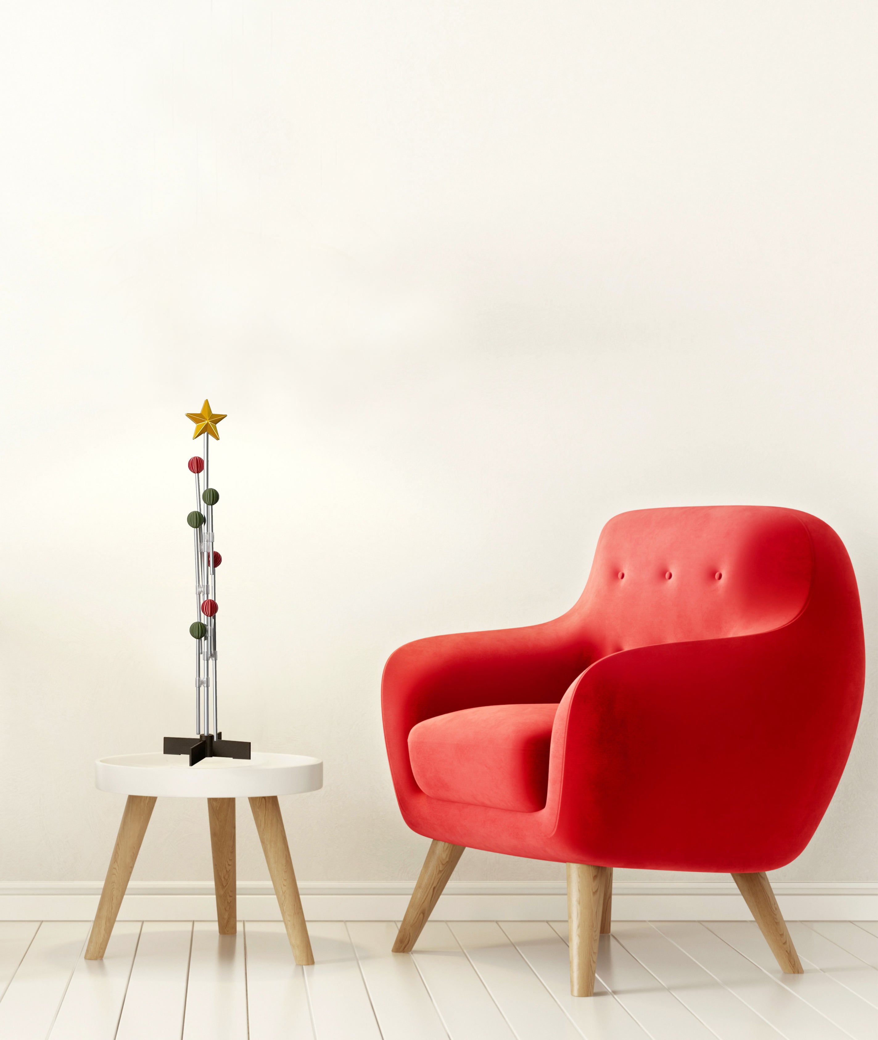 Red armchair next to a small round table with a red and green decorative sculpture on a white background