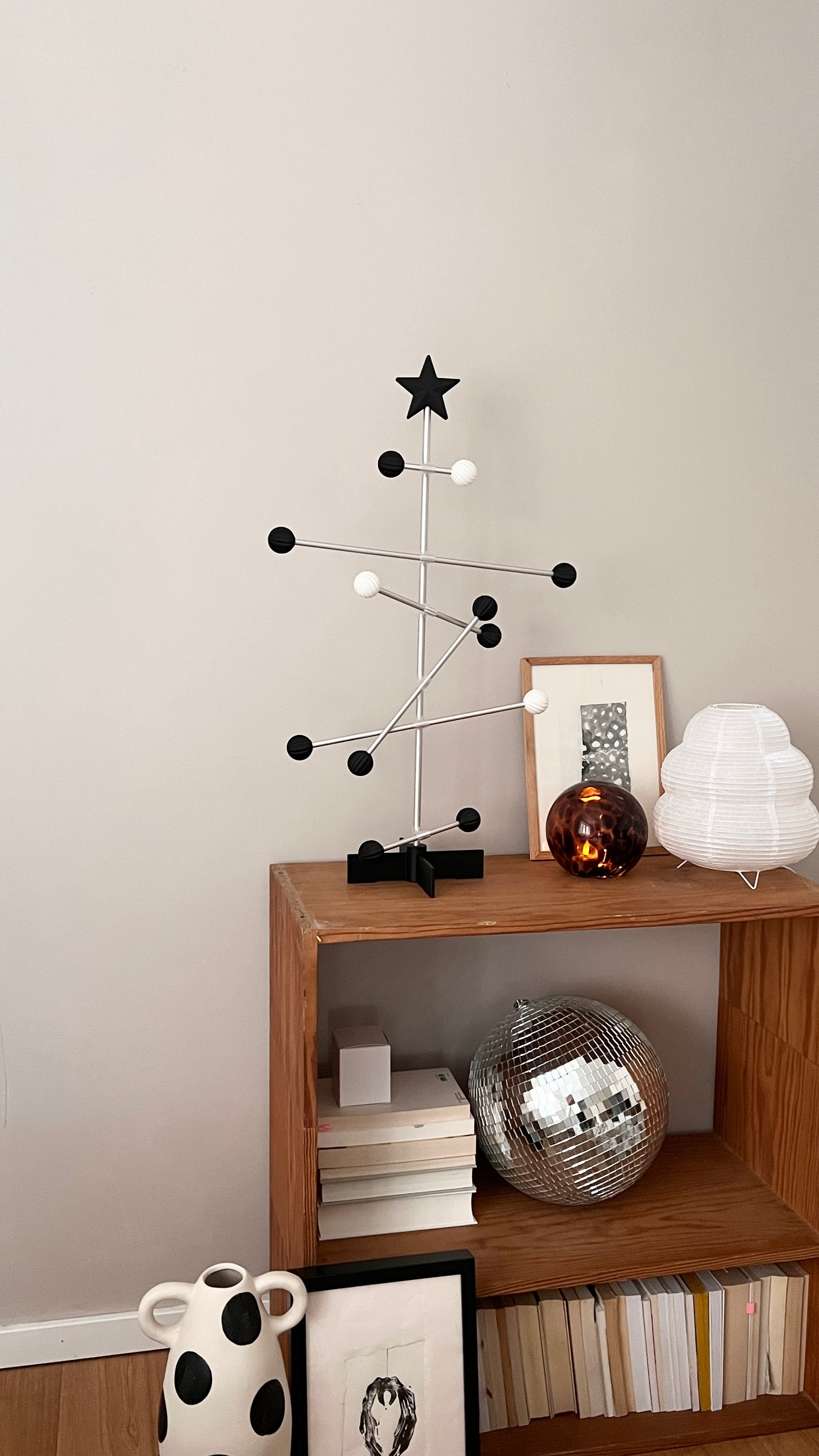 Modern interior with a wooden shelf displaying decorative items against a plain wall.