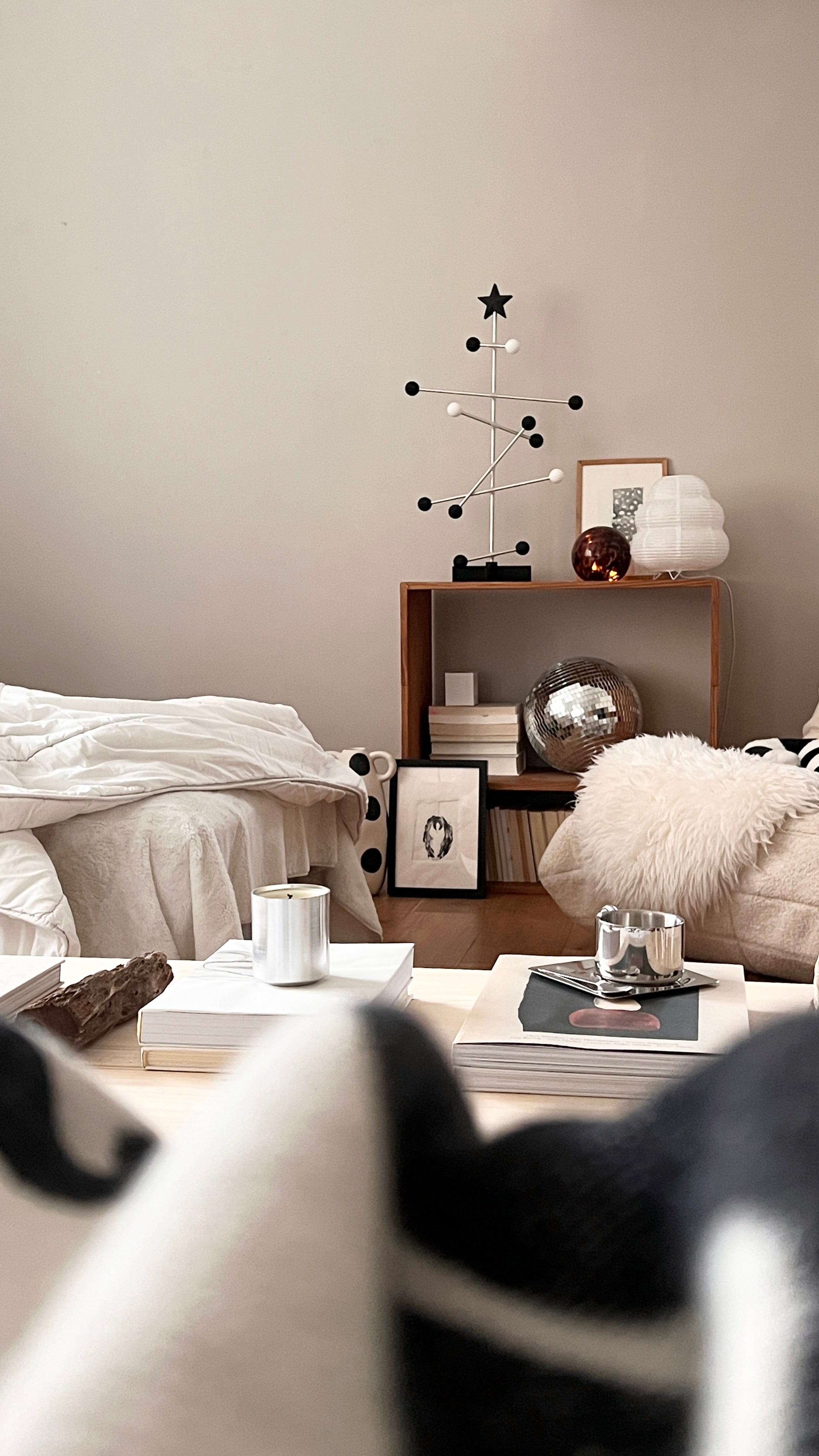 Modern living room with a coffee table, armchair, and decorative items.