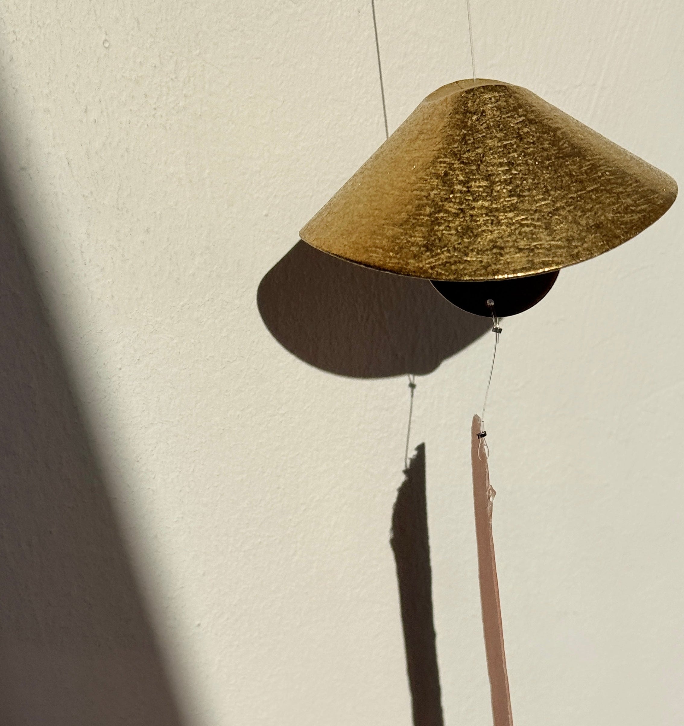 Pendant light with a textured shade on a neutral background