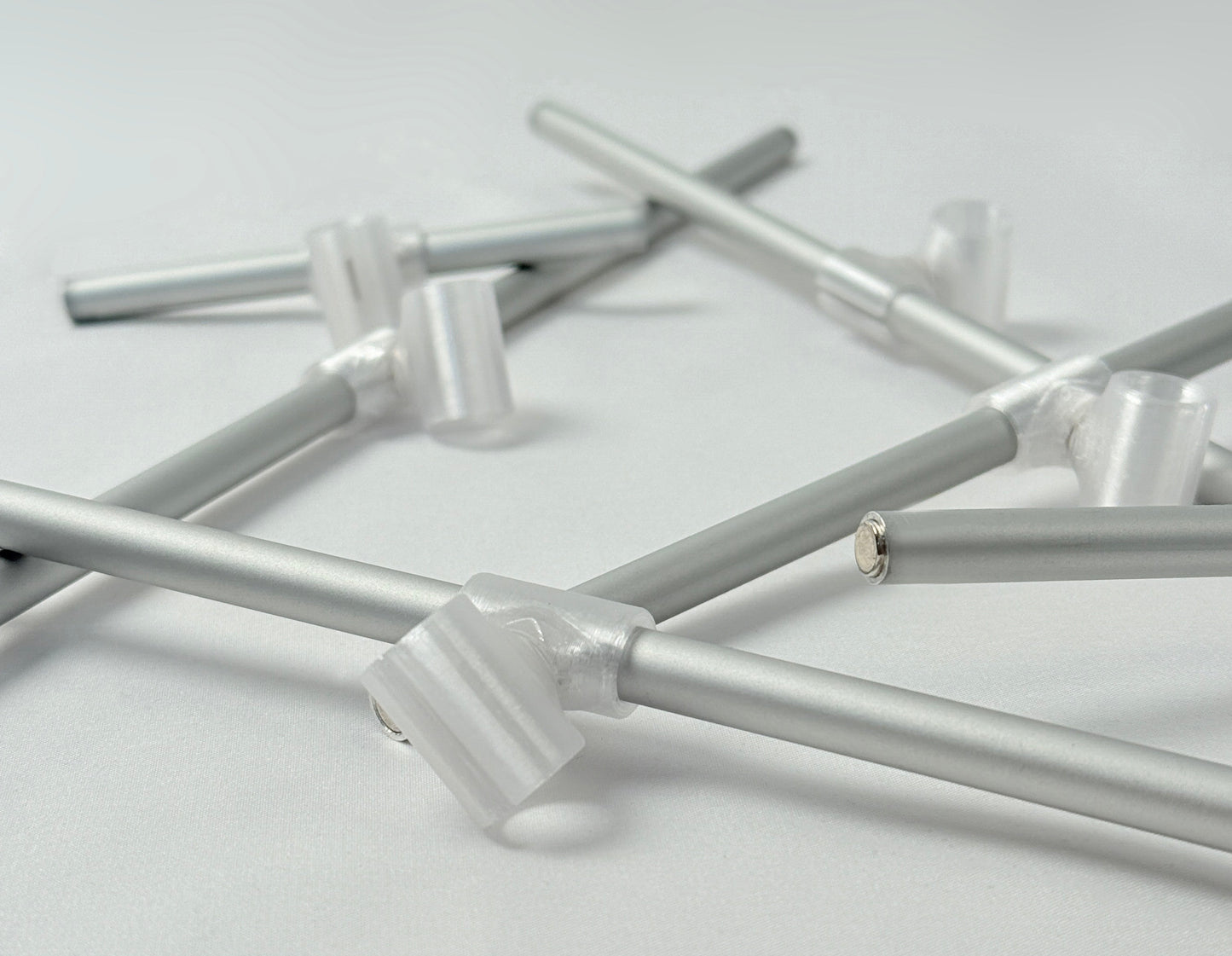 Metallic rode with 3D print connector and magnets on a light gray background