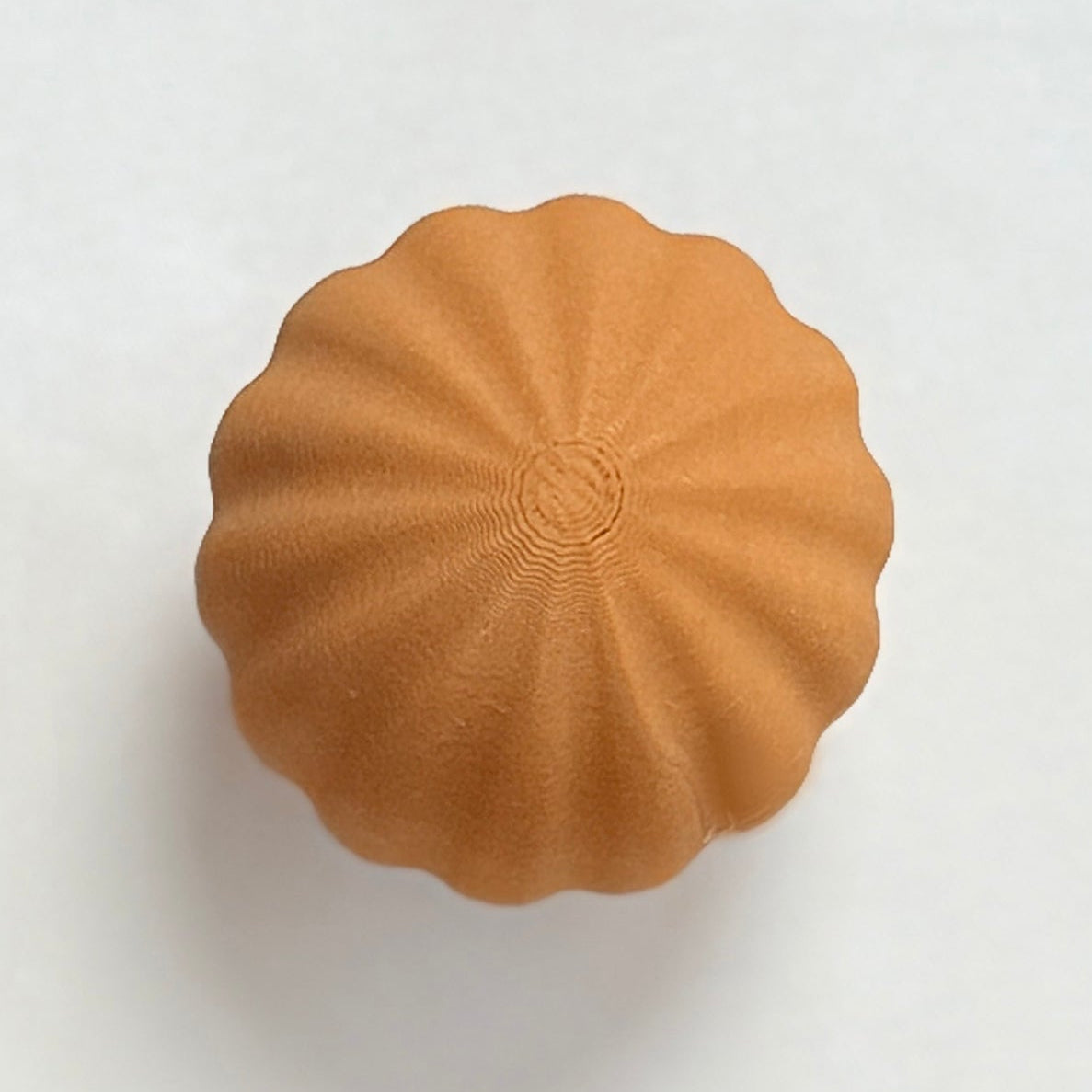 Six round, textured knobs in brown and beige on a white background