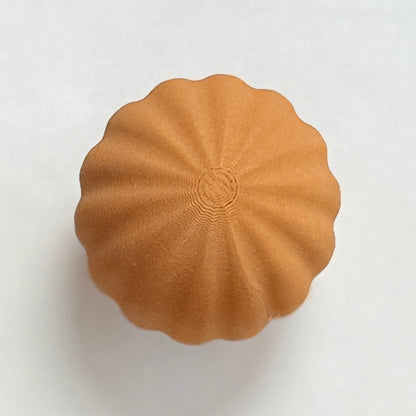 Six round, textured knobs in brown and beige on a white background