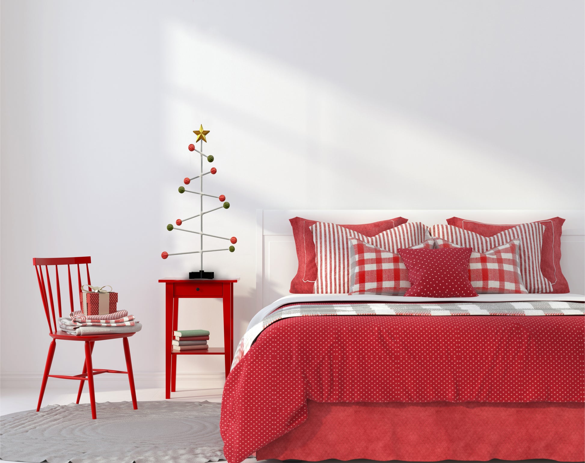 Bedroom with red bedding and decorative modern Christmas tree on the bed side table