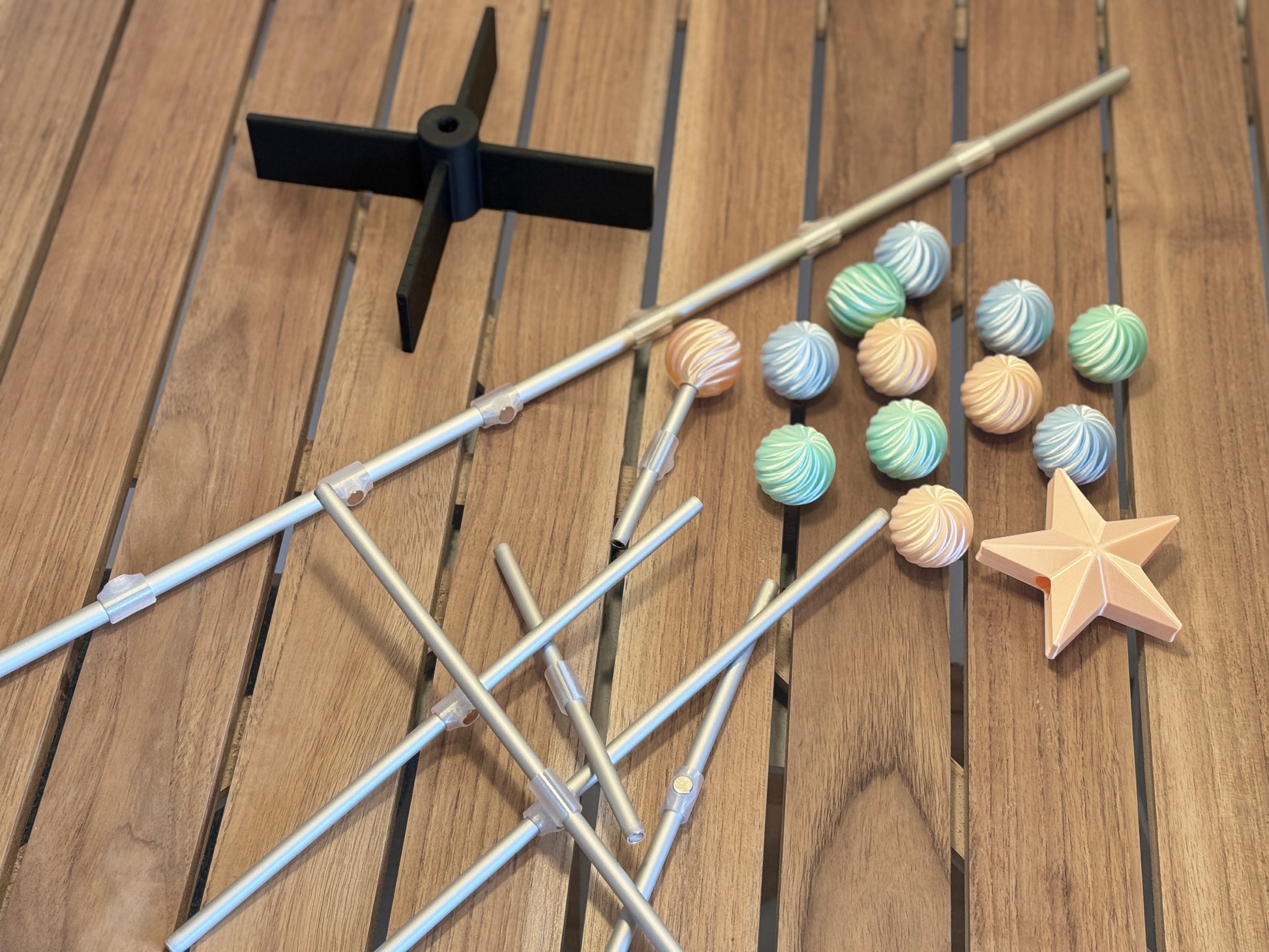 Modern modular for Easter tree items including sticks, colorful ornament, and a star on a wooden surface
