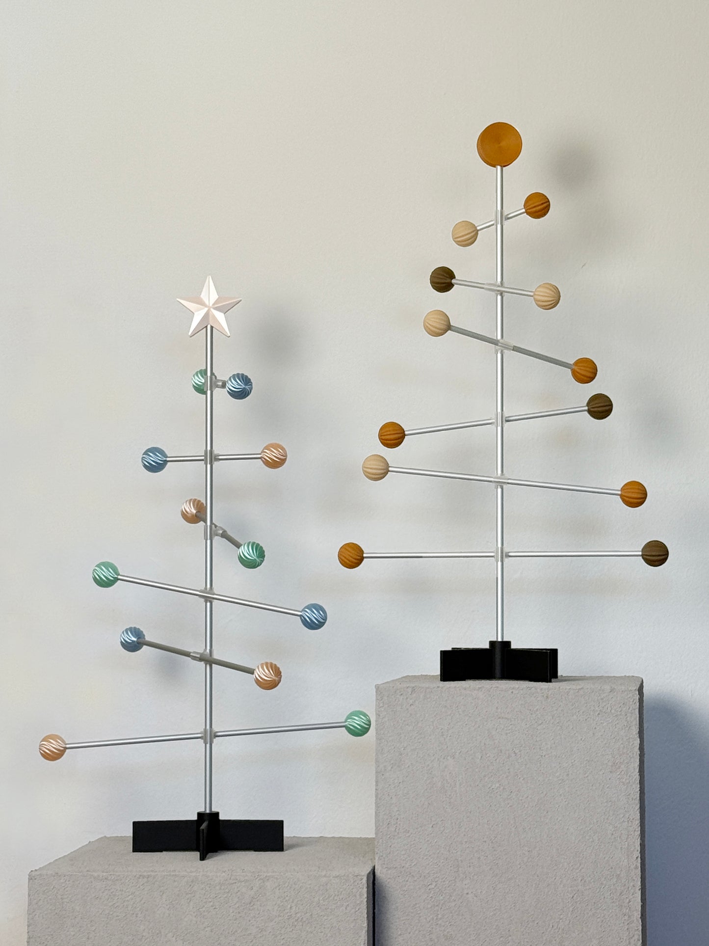 Moderner dekorativer modularer Baum aus Metall mit pastellfarbenen Kugeln auf neutralem Hintergrund