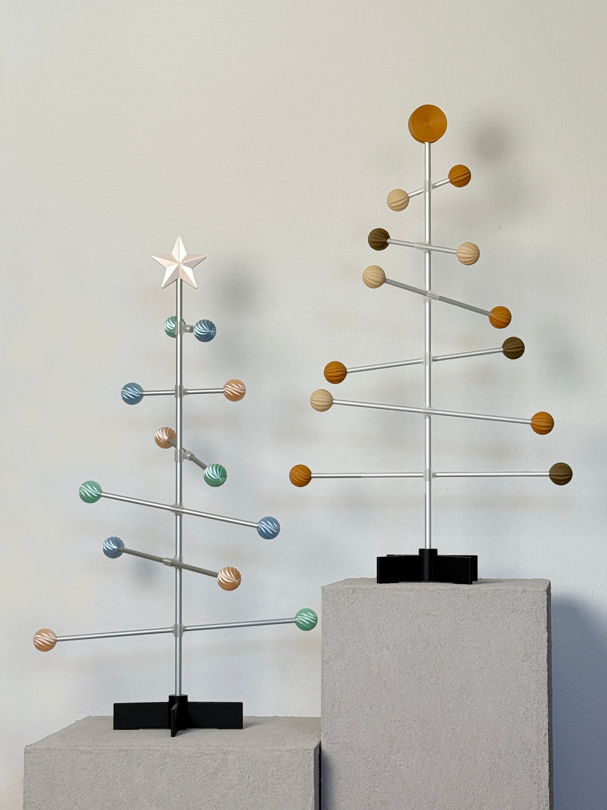 Moderner dekorativer modularer Baum aus Metall mit pastellfarbenen Kugeln auf neutralem Hintergrund