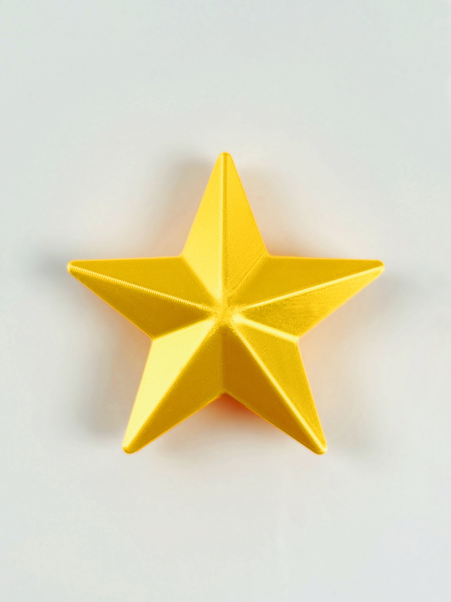 3D print Yellow star object/ ornament on a light gray background