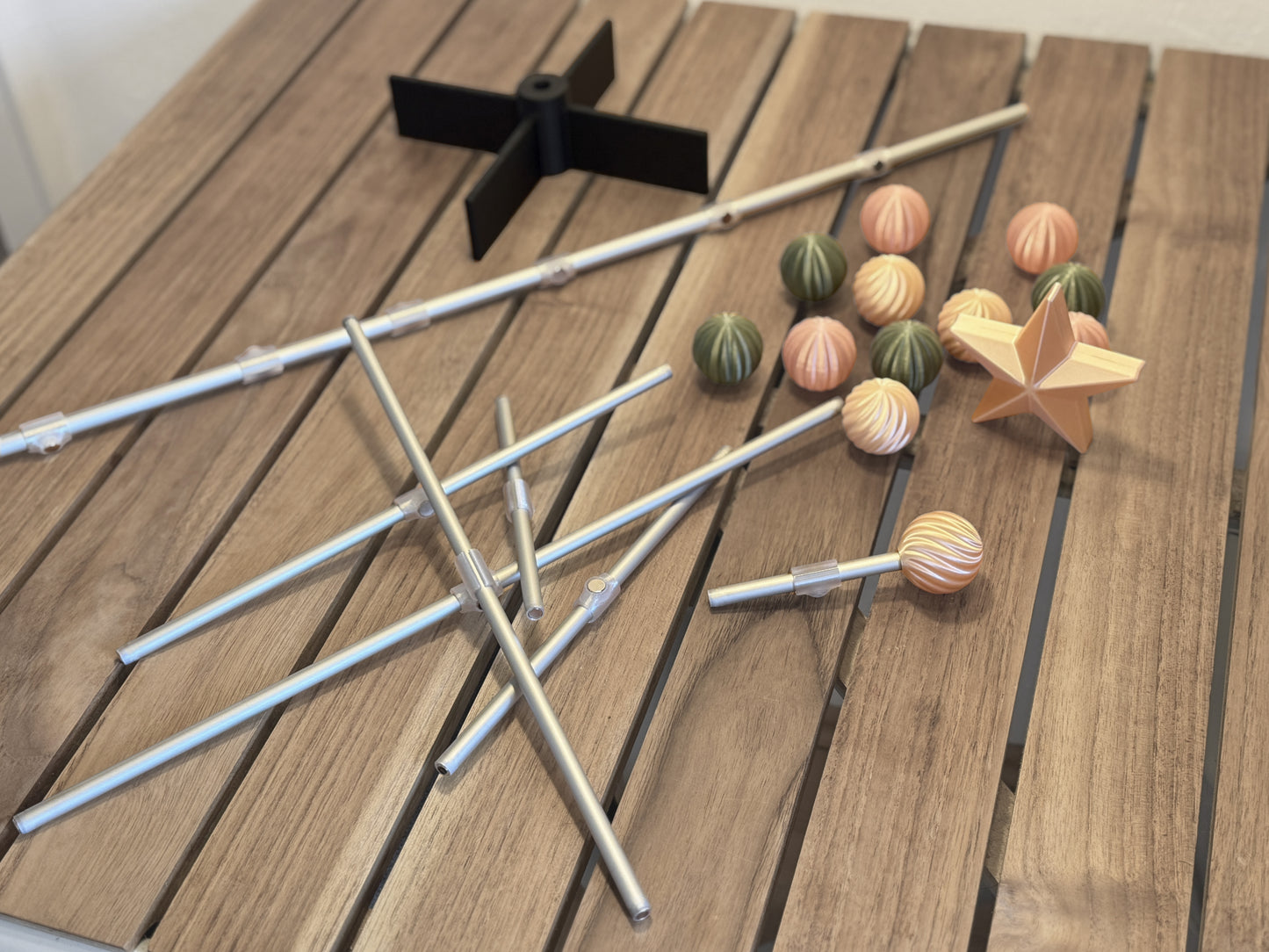 Modern modular for Easter tree items including sticks, colorful ornament, and a star on a wooden surface
