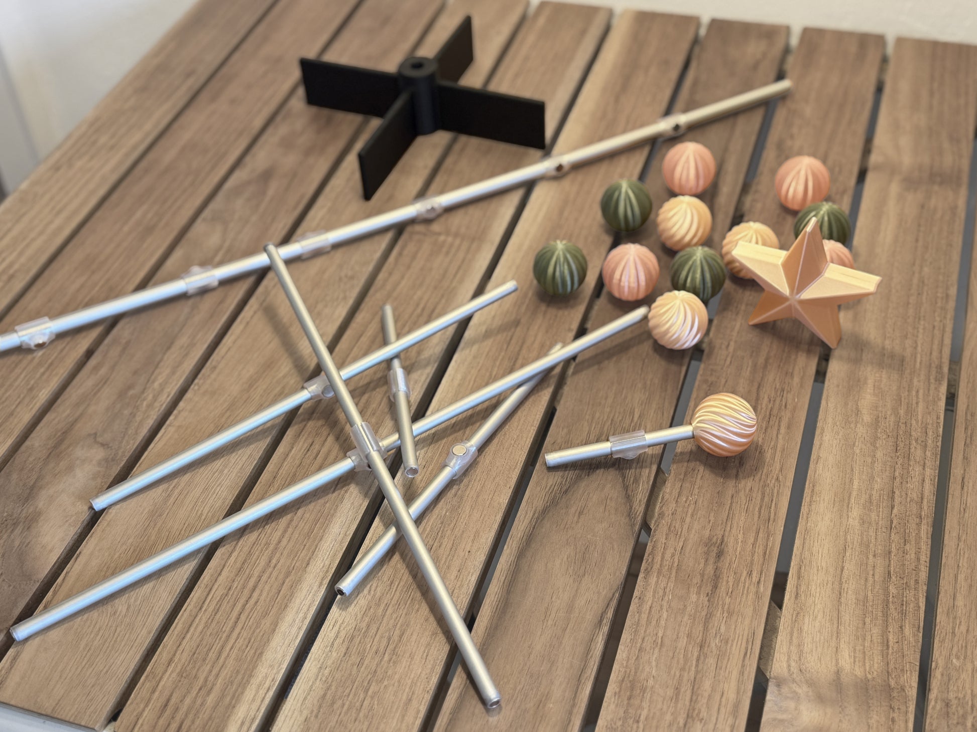 Modern modular for Easter tree items including sticks, colorful ornament, and a star on a wooden surface
