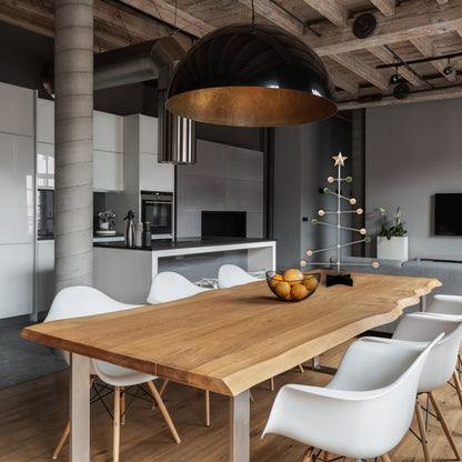 Modern kitchen and dining area with wooden table and white chairs. decorative modern pastel colored tree stand on the table.